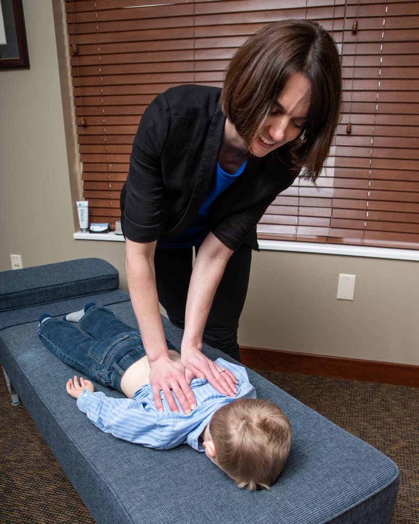 Dr Ashley Willow adjusting the back of a young patient at Back in Balance Family Chiropractic.